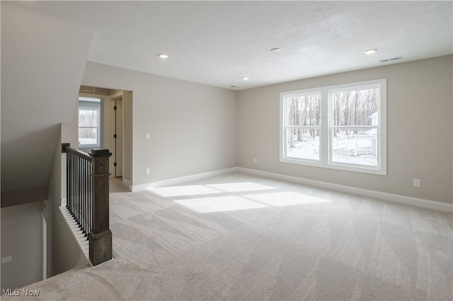 empty room with light colored carpet, baseboards, and recessed lighting