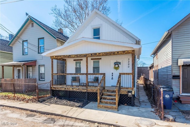 view of front of property with a porch and fence