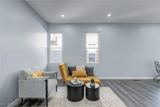 living area featuring recessed lighting, baseboards, and wood finished floors