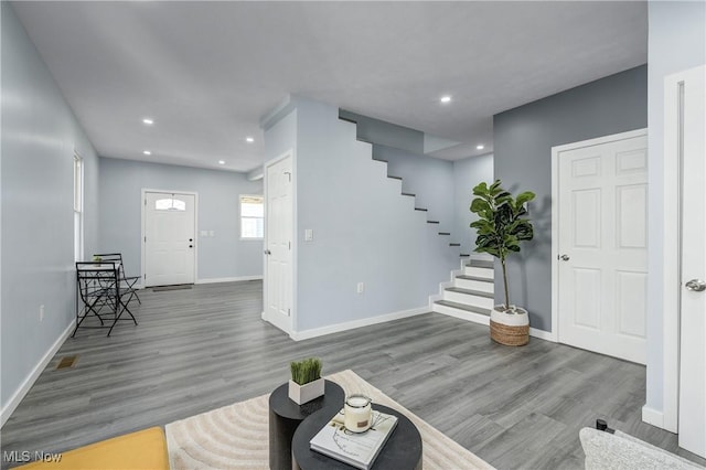 foyer with stairs, recessed lighting, wood finished floors, and baseboards