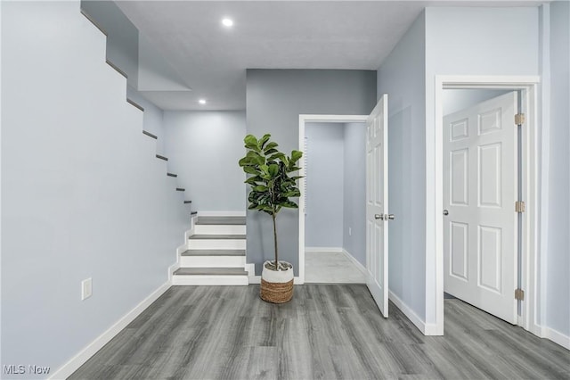 entryway with stairs, recessed lighting, wood finished floors, and baseboards