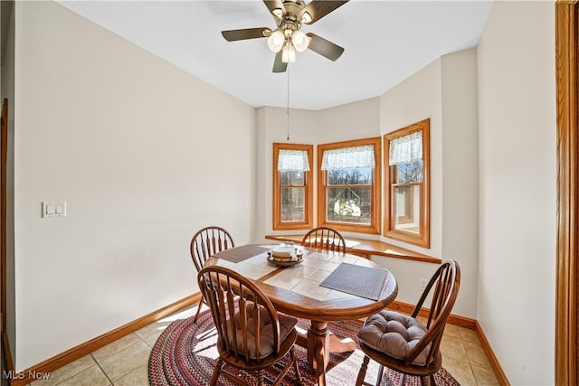 dining room with light tile patterned floors, baseboards, and ceiling fan