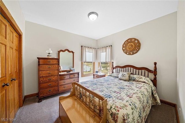 carpeted bedroom with a closet and baseboards