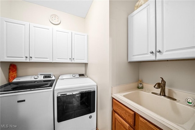 laundry room featuring cabinet space, washing machine and dryer, and a sink