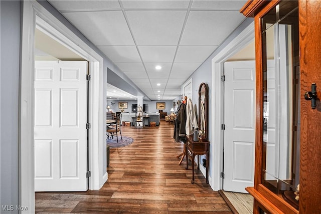 corridor with recessed lighting, a drop ceiling, and wood finished floors