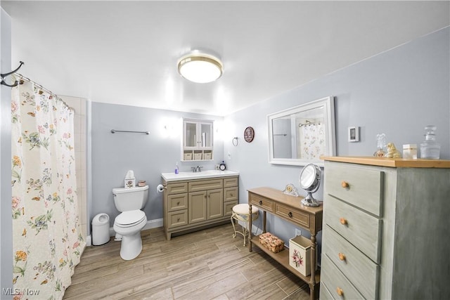 full bathroom featuring toilet, vanity, a shower with shower curtain, and wood finished floors