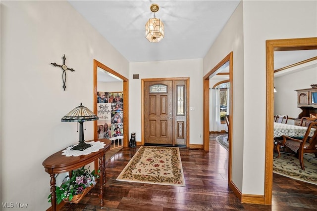 foyer featuring baseboards and wood finished floors