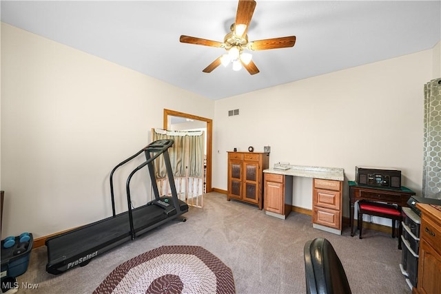 exercise room featuring visible vents, light colored carpet, baseboards, and ceiling fan