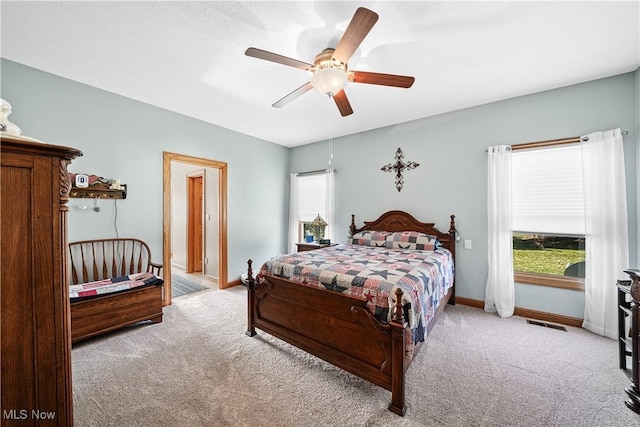 bedroom featuring baseboards, multiple windows, light colored carpet, and visible vents