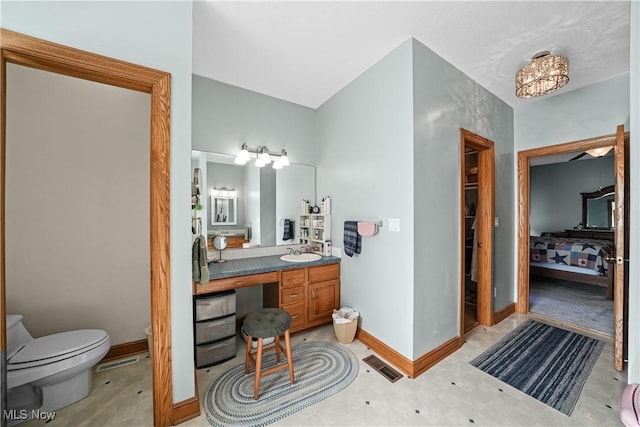 bathroom with visible vents, baseboards, toilet, and vanity