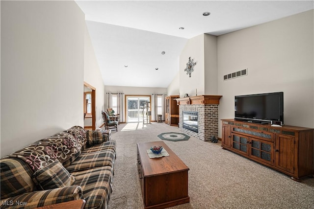 living area with visible vents, carpet floors, high vaulted ceiling, and a brick fireplace