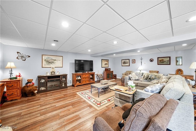 living area with recessed lighting, light wood-style floors, baseboards, and a paneled ceiling