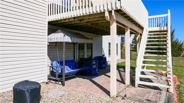 view of patio featuring stairway and fence