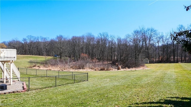 view of yard with a forest view and fence