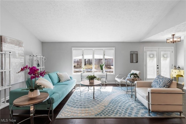 living room featuring french doors, a textured ceiling, lofted ceiling, and hardwood / wood-style flooring