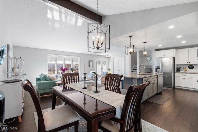 dining area with dark wood finished floors, an inviting chandelier, stairs, and a textured ceiling