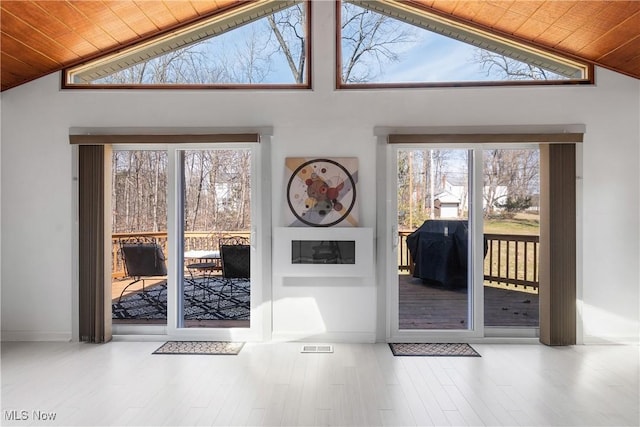 doorway to outside featuring wood finished floors, lofted ceiling, and wooden ceiling