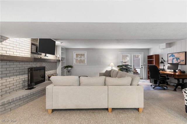 living area with light carpet, a brick fireplace, a textured ceiling, and a wealth of natural light