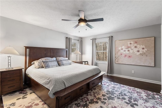 bedroom with ceiling fan, baseboards, a textured ceiling, and light wood-style flooring