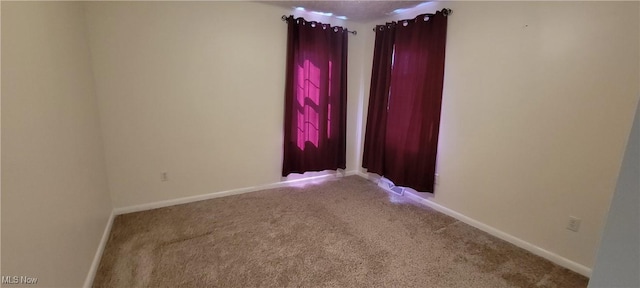 carpeted empty room with baseboards