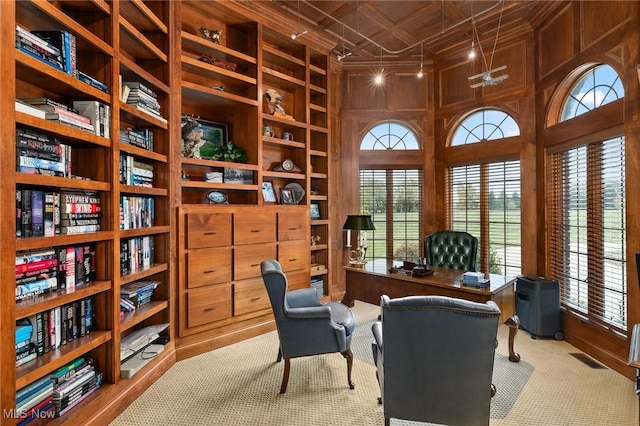 office space featuring wooden walls, visible vents, built in shelves, carpet floors, and an ornate ceiling