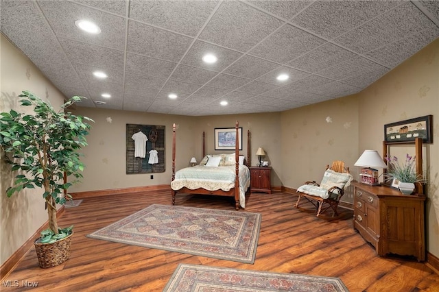 bedroom with recessed lighting, wood finished floors, and baseboards