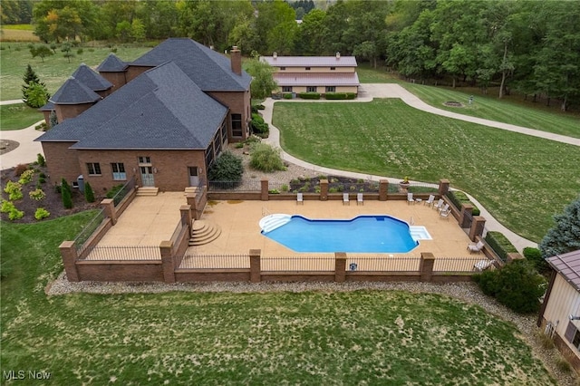 view of pool with a fenced backyard, a yard, a diving board, a fenced in pool, and a patio area