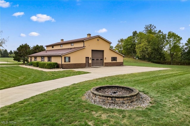 rear view of house featuring a yard, brick siding, concrete driveway, and a chimney