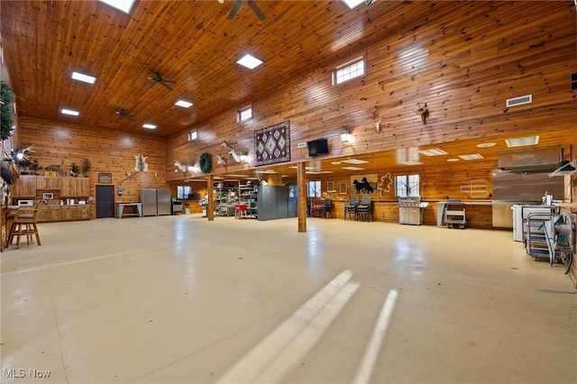 garage with wooden walls, visible vents, wood ceiling, and a ceiling fan