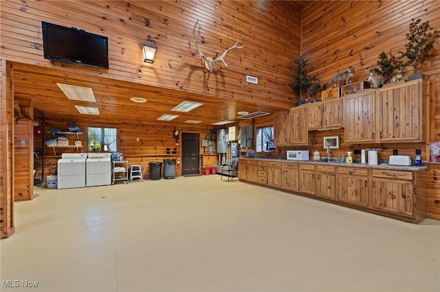 garage featuring washing machine and dryer and wood walls