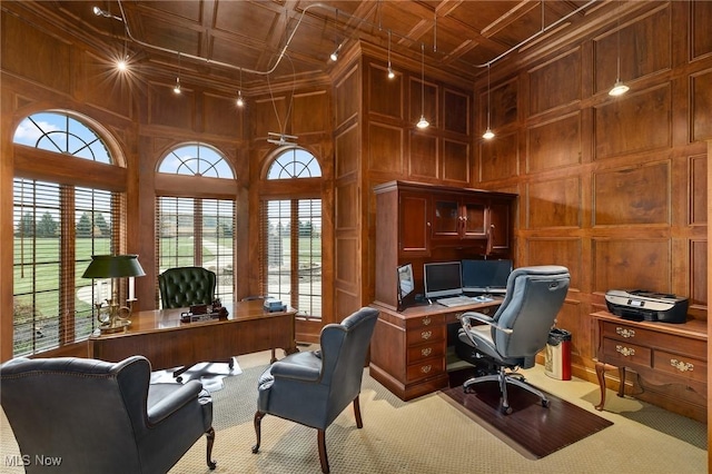 office area featuring wooden walls, carpet flooring, coffered ceiling, and a decorative wall