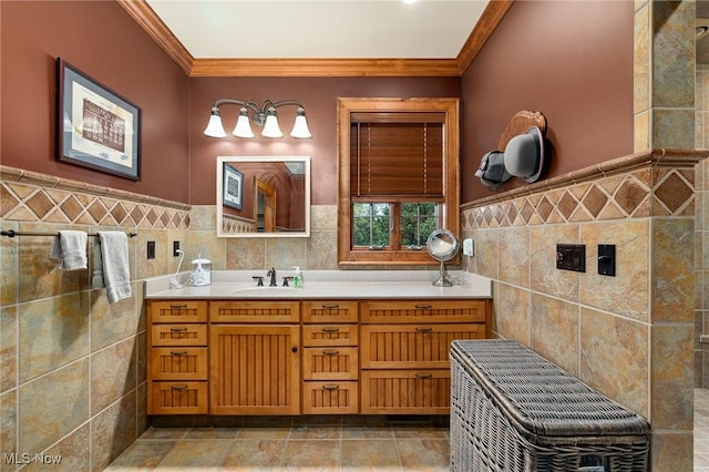 bathroom with a wainscoted wall, vanity, tile walls, and crown molding