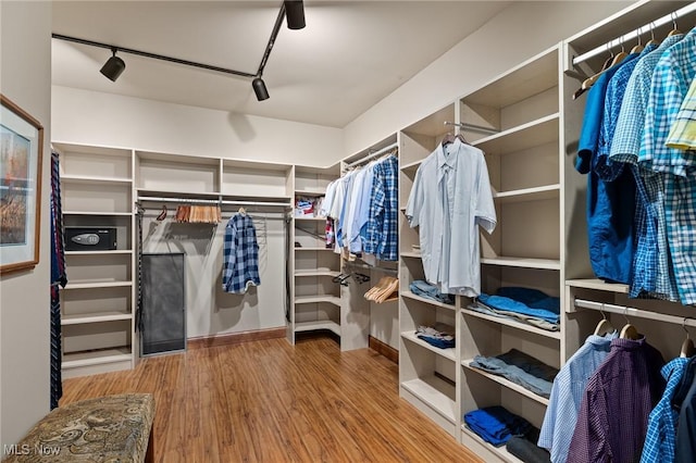 walk in closet with wood finished floors