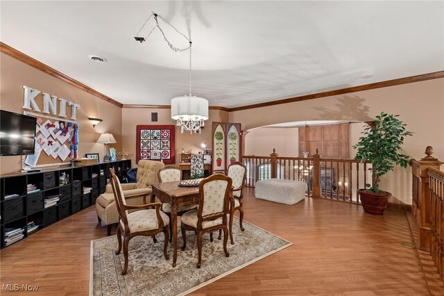 dining room featuring visible vents, ornamental molding, an inviting chandelier, and wood finished floors