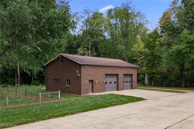 garage with concrete driveway and fence