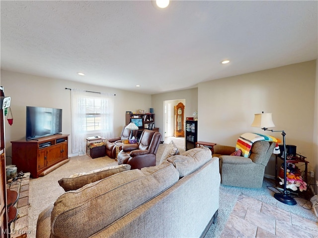 living room featuring recessed lighting, a textured ceiling, stone finish flooring, and baseboards