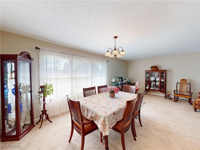 dining area featuring a chandelier, a textured ceiling, and light carpet