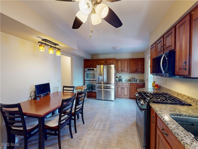 kitchen with light stone counters, appliances with stainless steel finishes, and ceiling fan