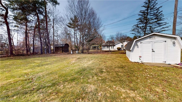 view of yard with an outbuilding, a fenced backyard, and a shed