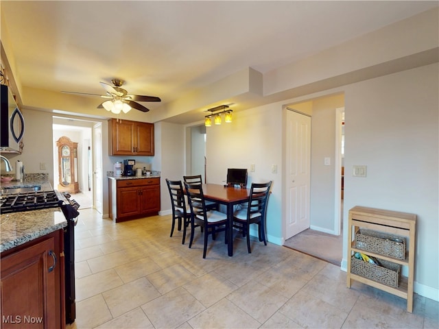 dining area with baseboards and ceiling fan