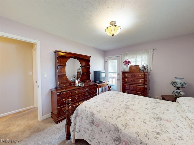 bedroom with light colored carpet and baseboards