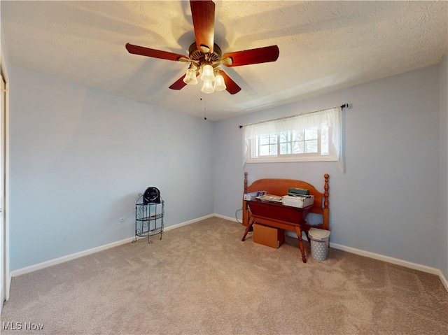 sitting room with a textured ceiling, baseboards, carpet, and a ceiling fan