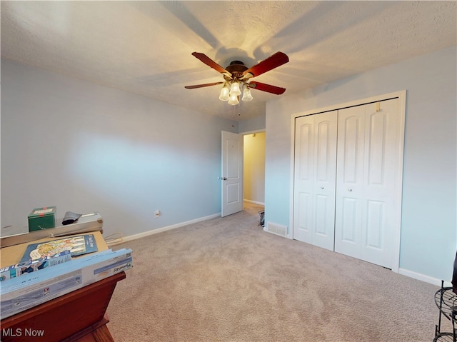 bedroom featuring a closet, a textured ceiling, baseboards, and carpet floors