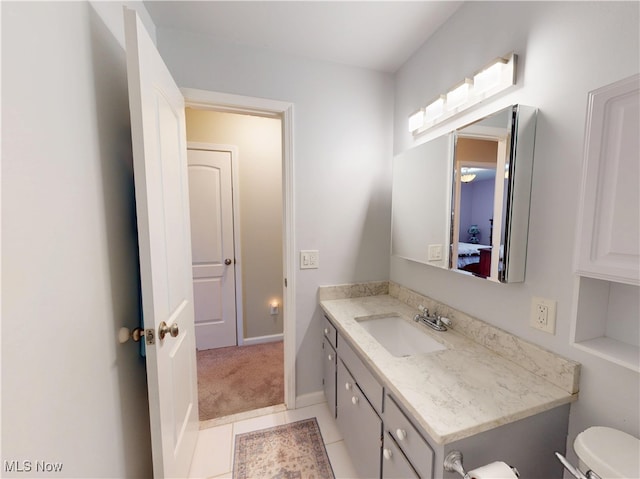 bathroom with tile patterned floors, toilet, vanity, and baseboards