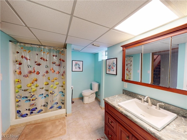 full bath with a shower with curtain, a paneled ceiling, toilet, and vanity