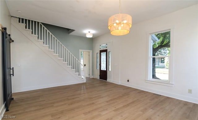 1640 Main St, Stockport, OH 43787 - entryway featuring stairs, light wood-type flooring, a chandelier, and baseboards