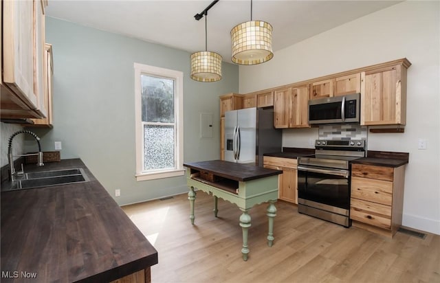 kitchen featuring light wood finished floors, visible vents, stainless steel appliances, and a sink