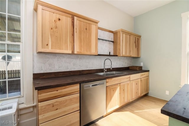 kitchen featuring a sink, light brown cabinets, light wood-type flooring, and stainless steel dishwasher