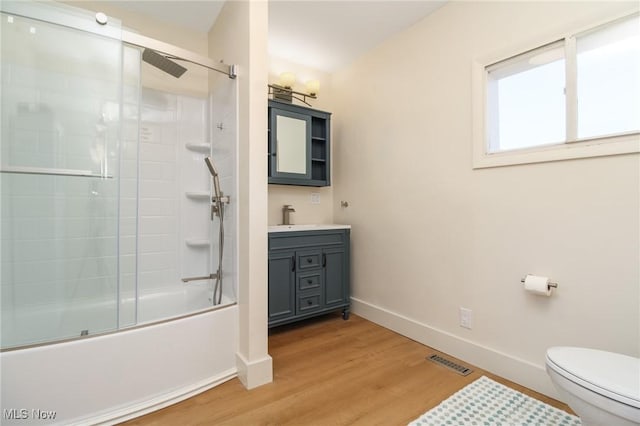 full bathroom featuring vanity, wood finished floors, visible vents, baseboards, and toilet