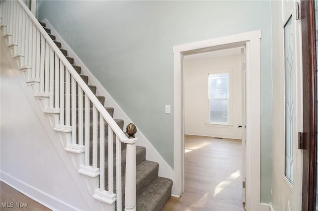 staircase with wood finished floors and baseboards